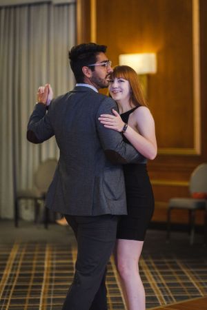 Couple sharing a joyful moment while dancing together at formal event.