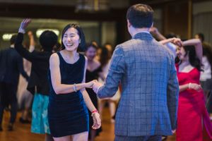 Dancers move gracefully across a crowded dance floor at an indoor event.