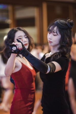 Dancers in red and black attire perform synchronized movements during a dance show.