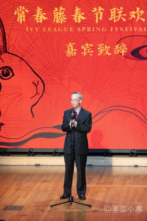 Stage presentation at Ivy League Spring Festival with Chinese characters on red backdrop.