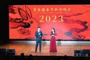 Red stage backdrop with Chinese characters and decorative elements for 2023 Spring Festival.