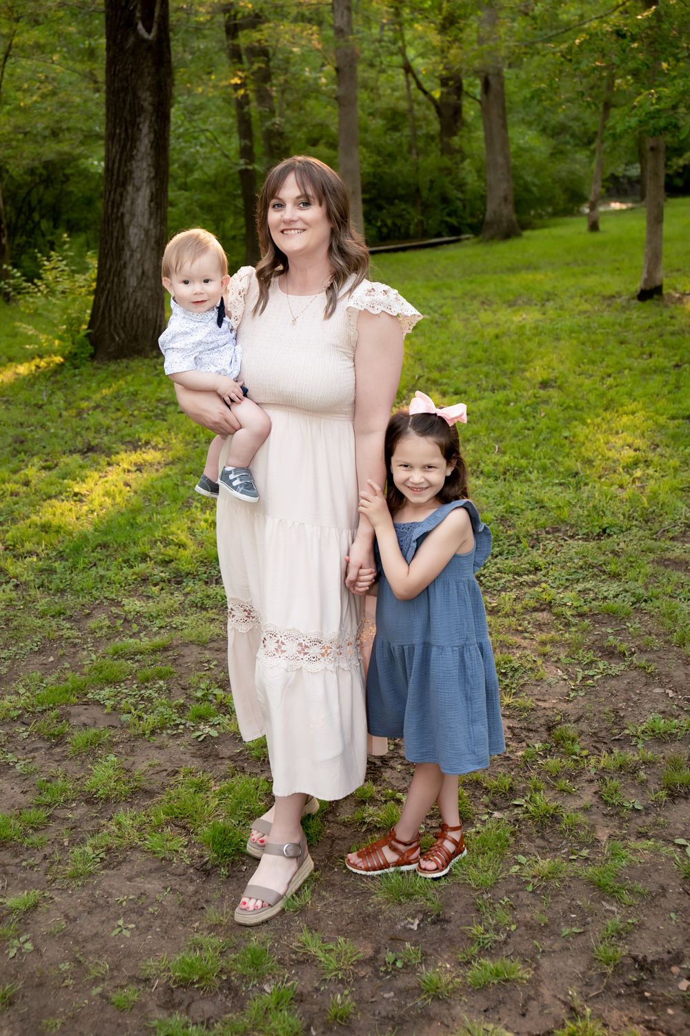 A family group poses together in a wooded setting wearing coordinated outfits.