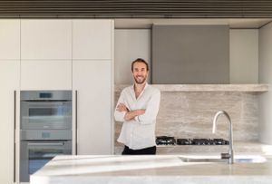 Modern luxury kitchen interior with stainless steel appliances and marble backsplash.