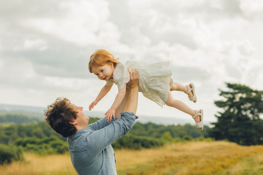 Dad with toddler flying in air
