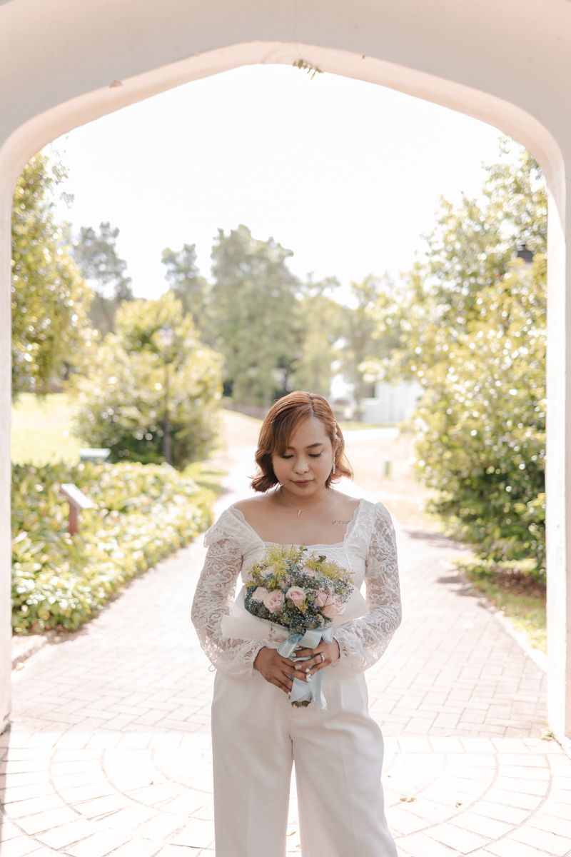 short hair bride in classy white lace top and pants at Fort Canning , Singapore