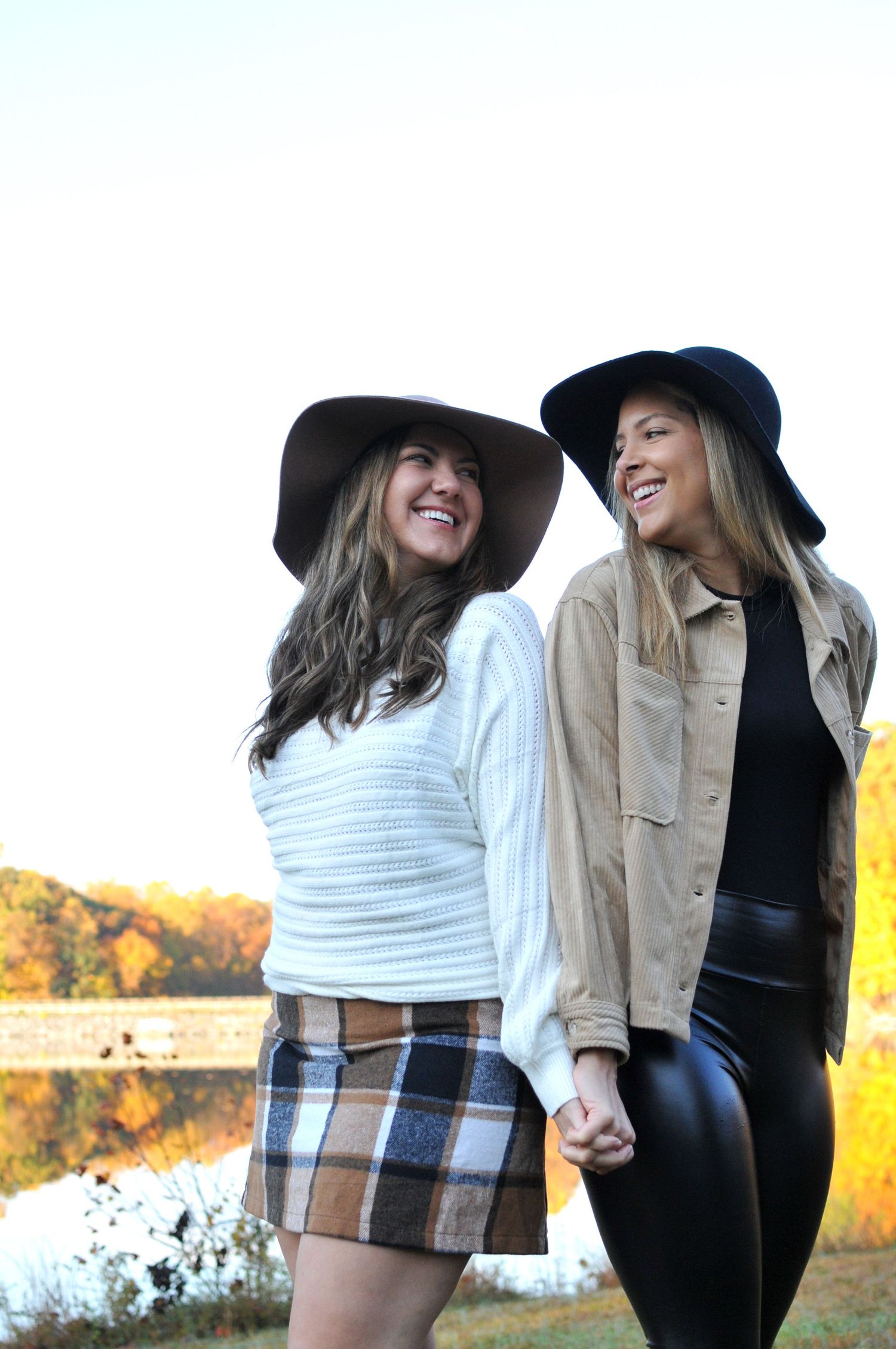 two women wearing hats smiling at each other