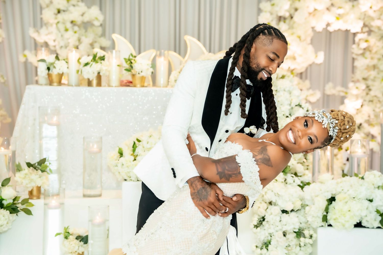 Romantic dance moment captured against backdrop of white floral decorations.
