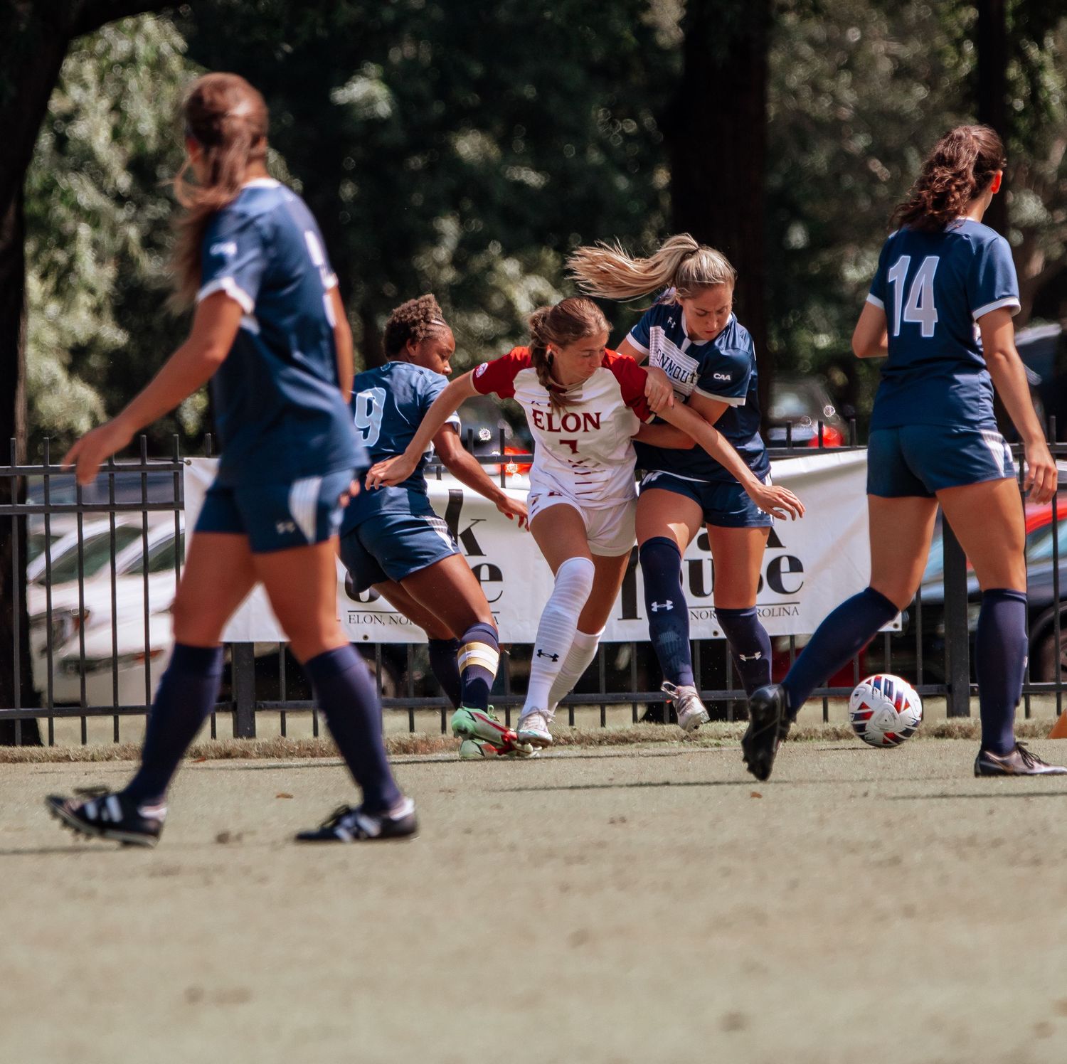 Intense soccer match action with players competing for ball during game.