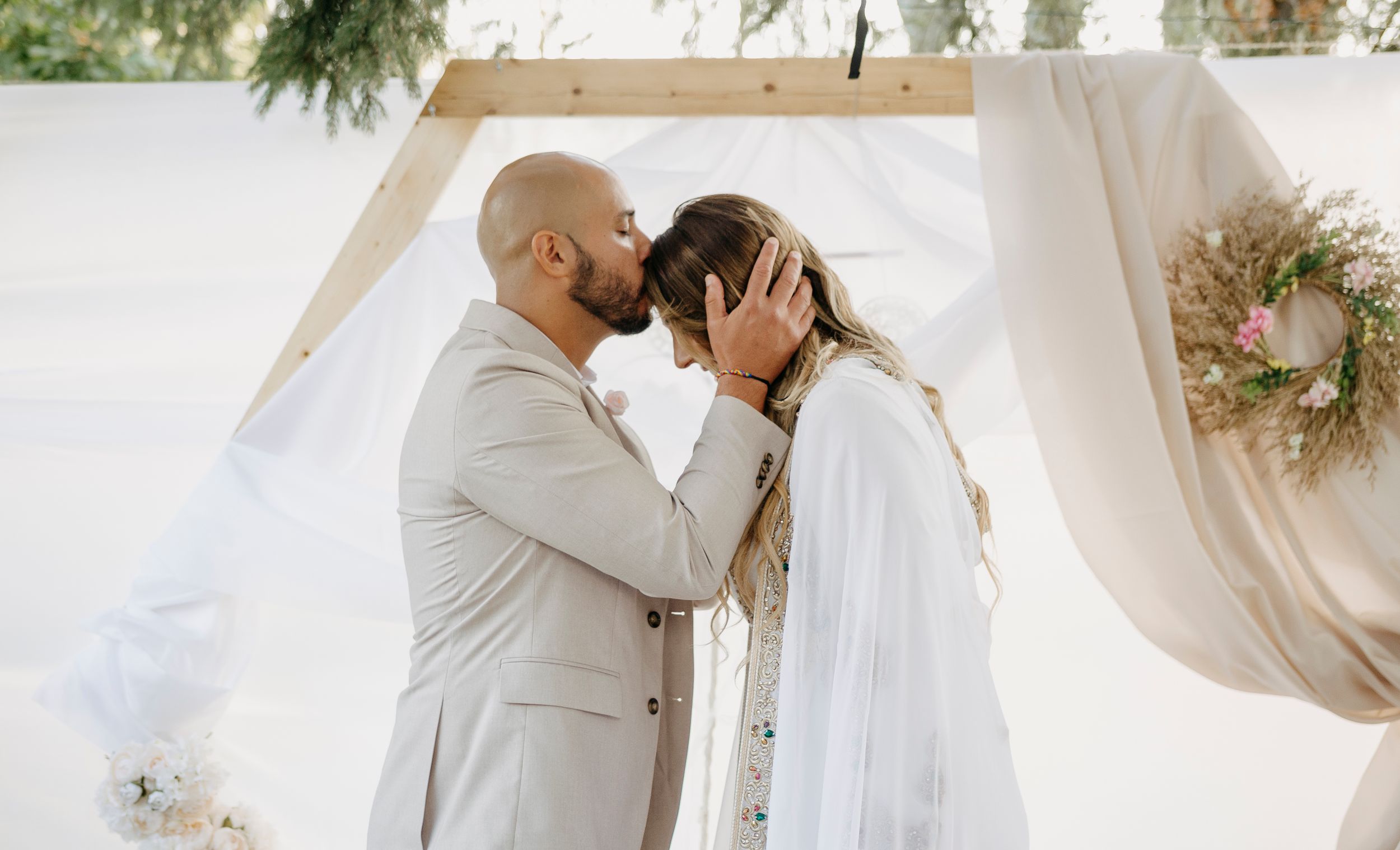 A romantic wedding sequence showing tender moments between a couple in white attire against a light background.