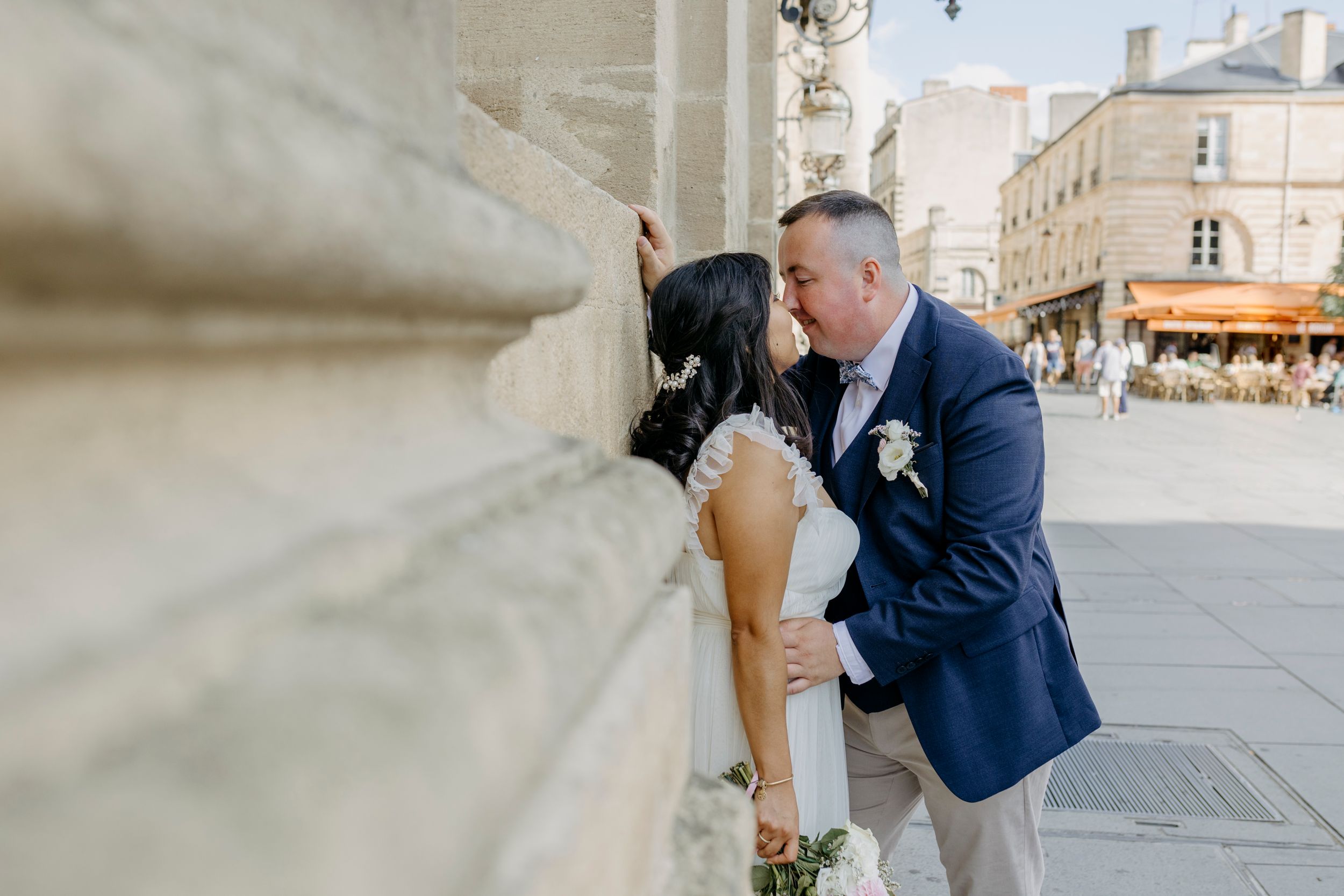 A romantic moment captured outside a historic stone cathedral.