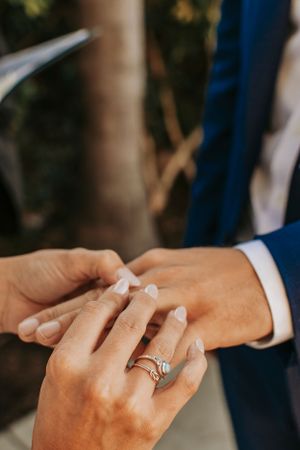 Close-up shot of hands exchanging wedding rings during an intimate ceremony moment.