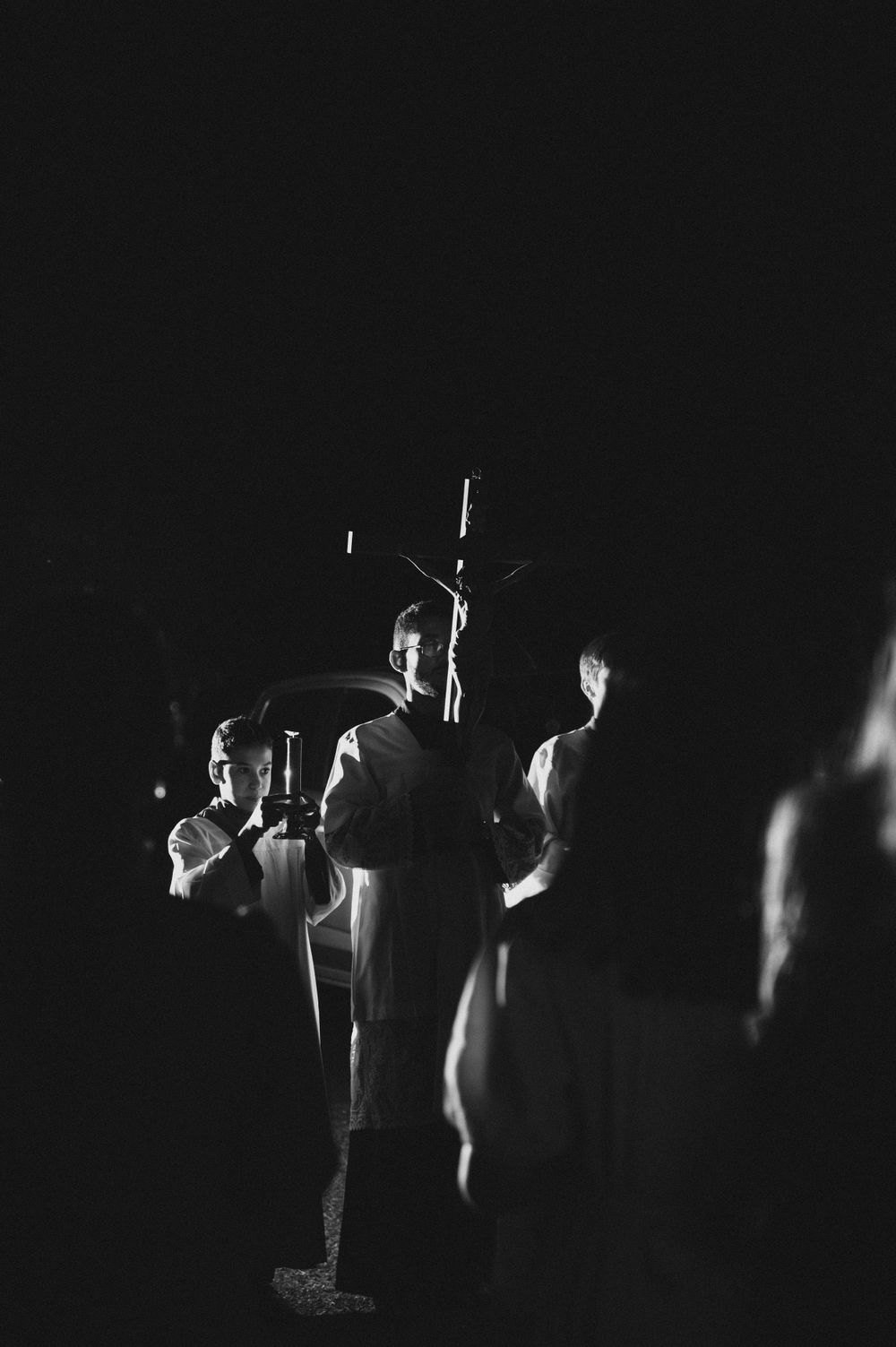 Dramatic black and white photo of figures illuminated in darkness.