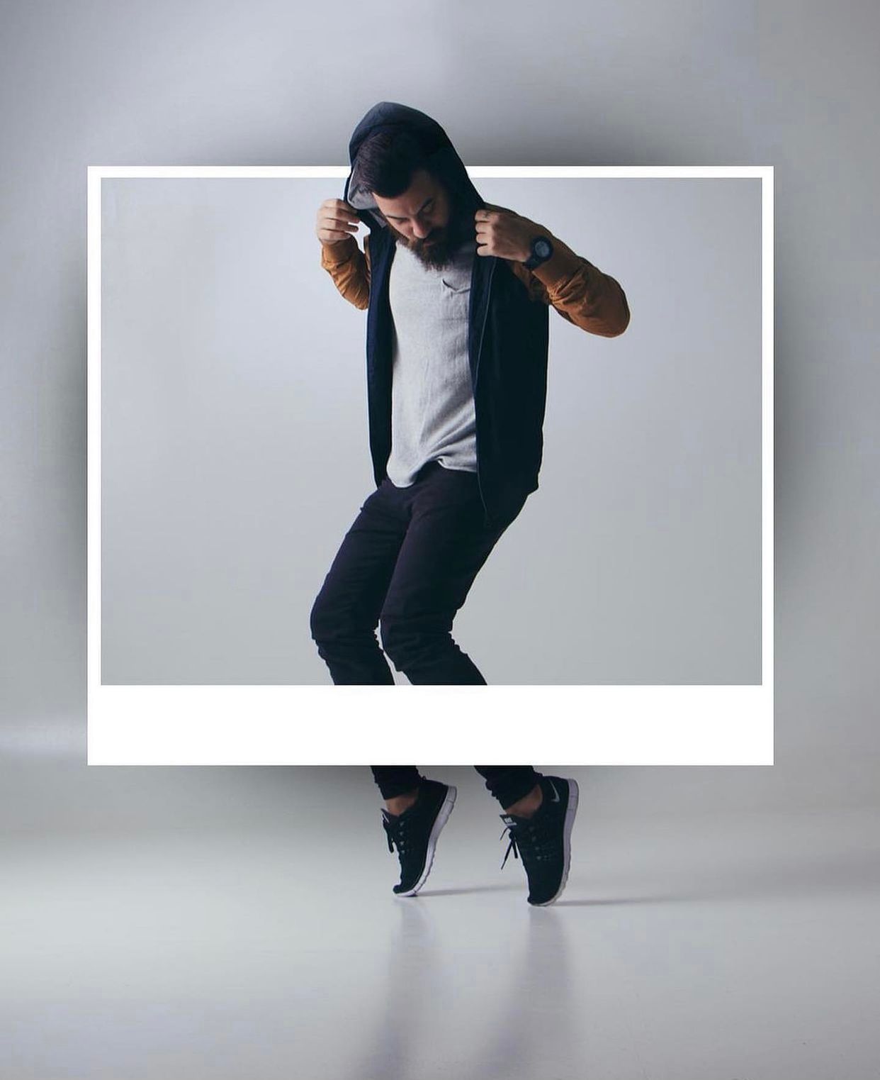 Figure in black clothing moving against white studio background.