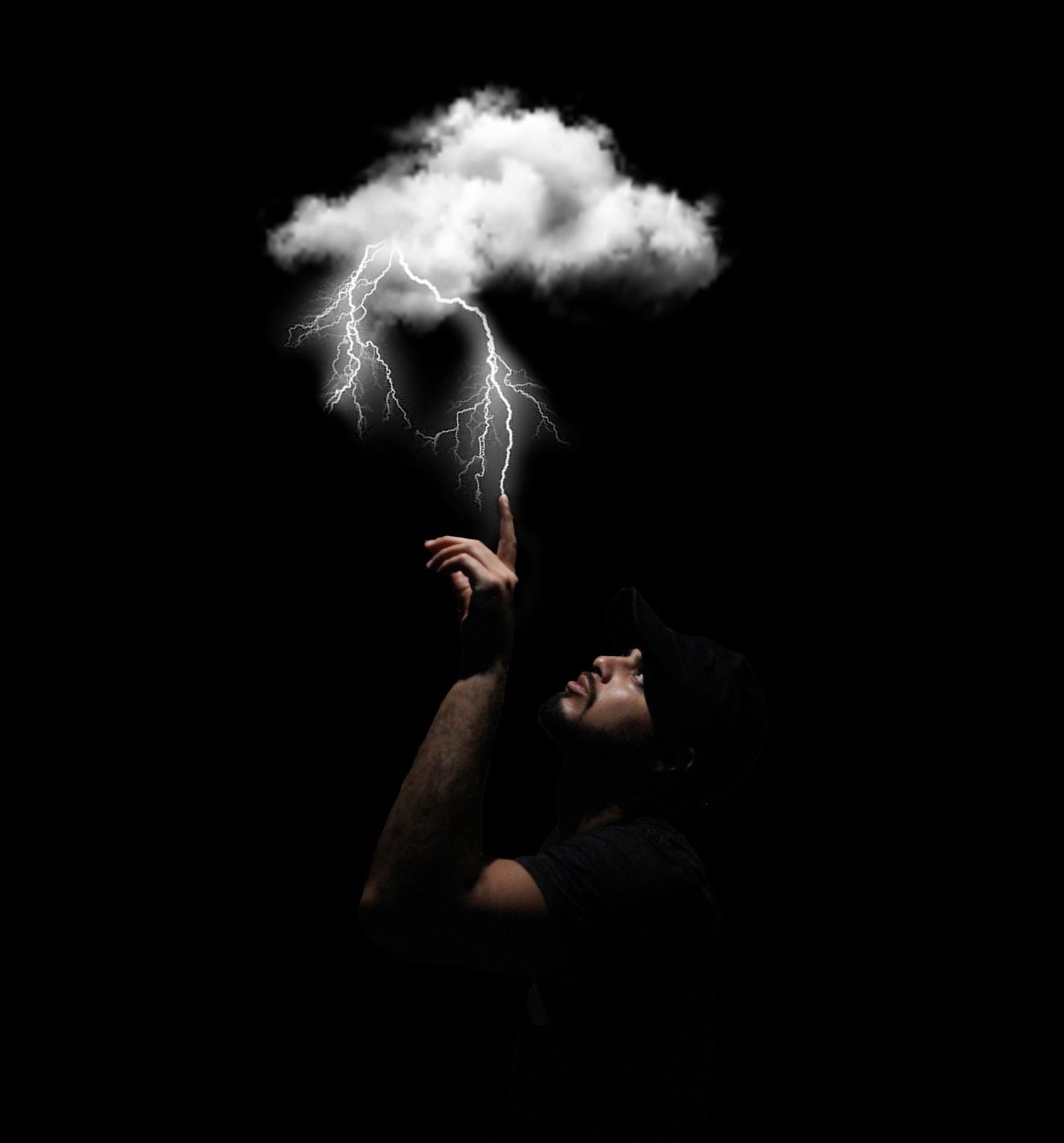 Artistic photo of a dark figure reaching up to touch a lightning storm cloud against black background.
