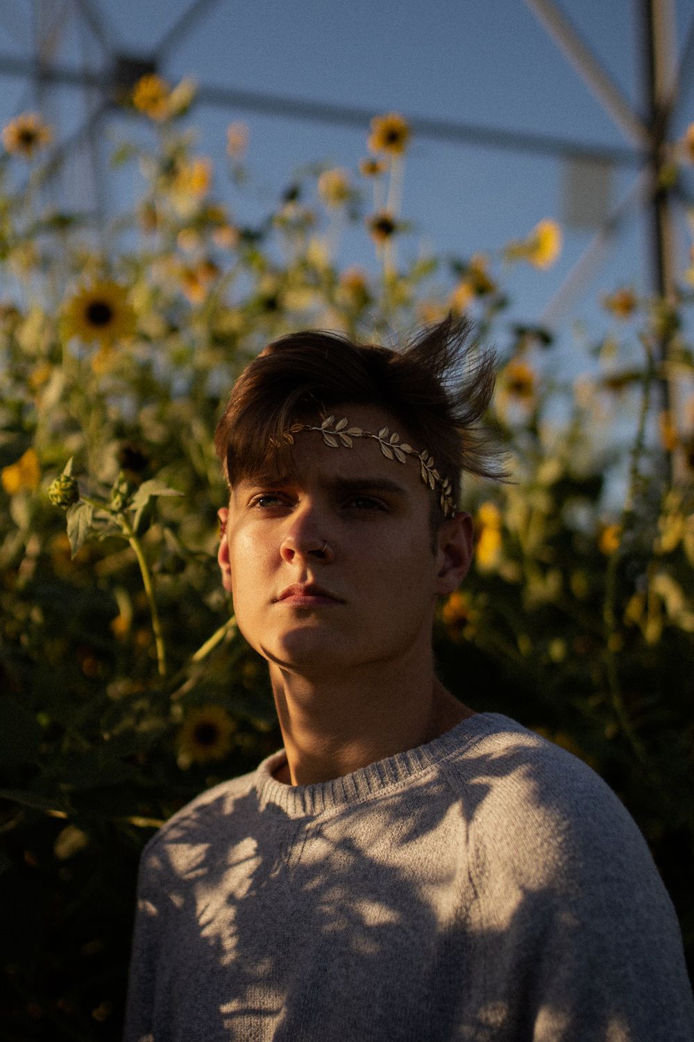 Portrait against sunflower field backdrop with delicate leaf crown decoration.