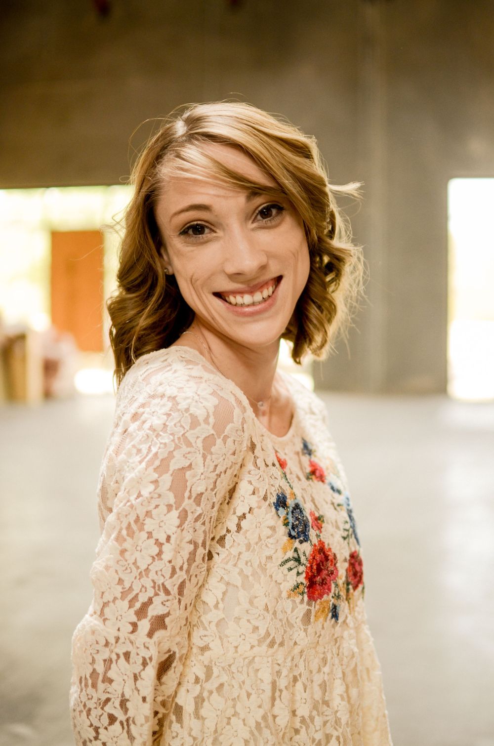 Portrait in vintage-style lace top with floral embroidery details.