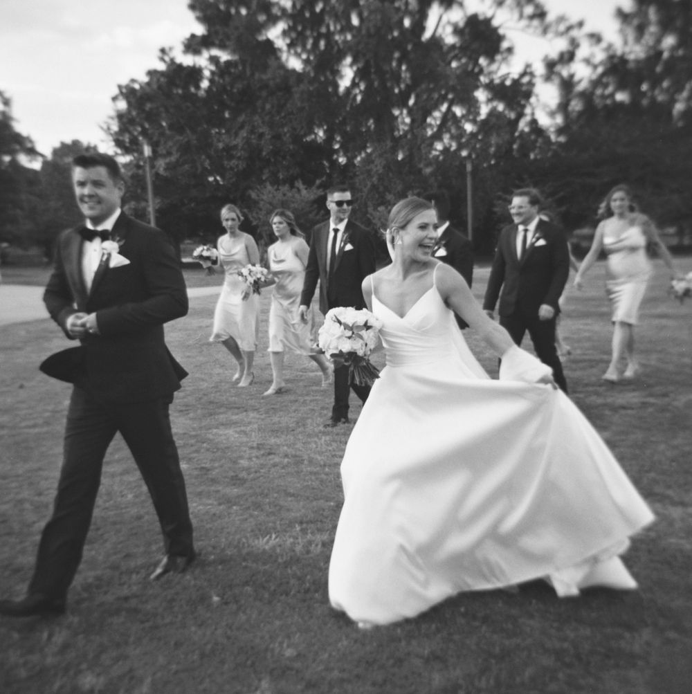 black and white film photo of wedding couple walking