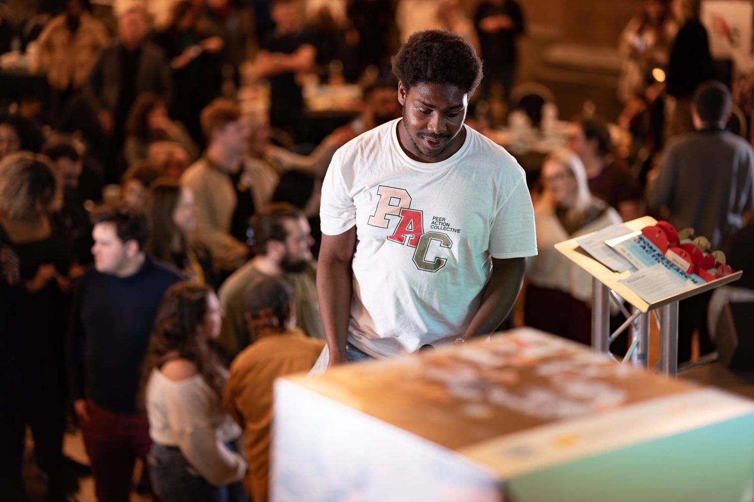 Guest browsing a stall at a busy outdoor community event with people socialising, candid event photography Southampton