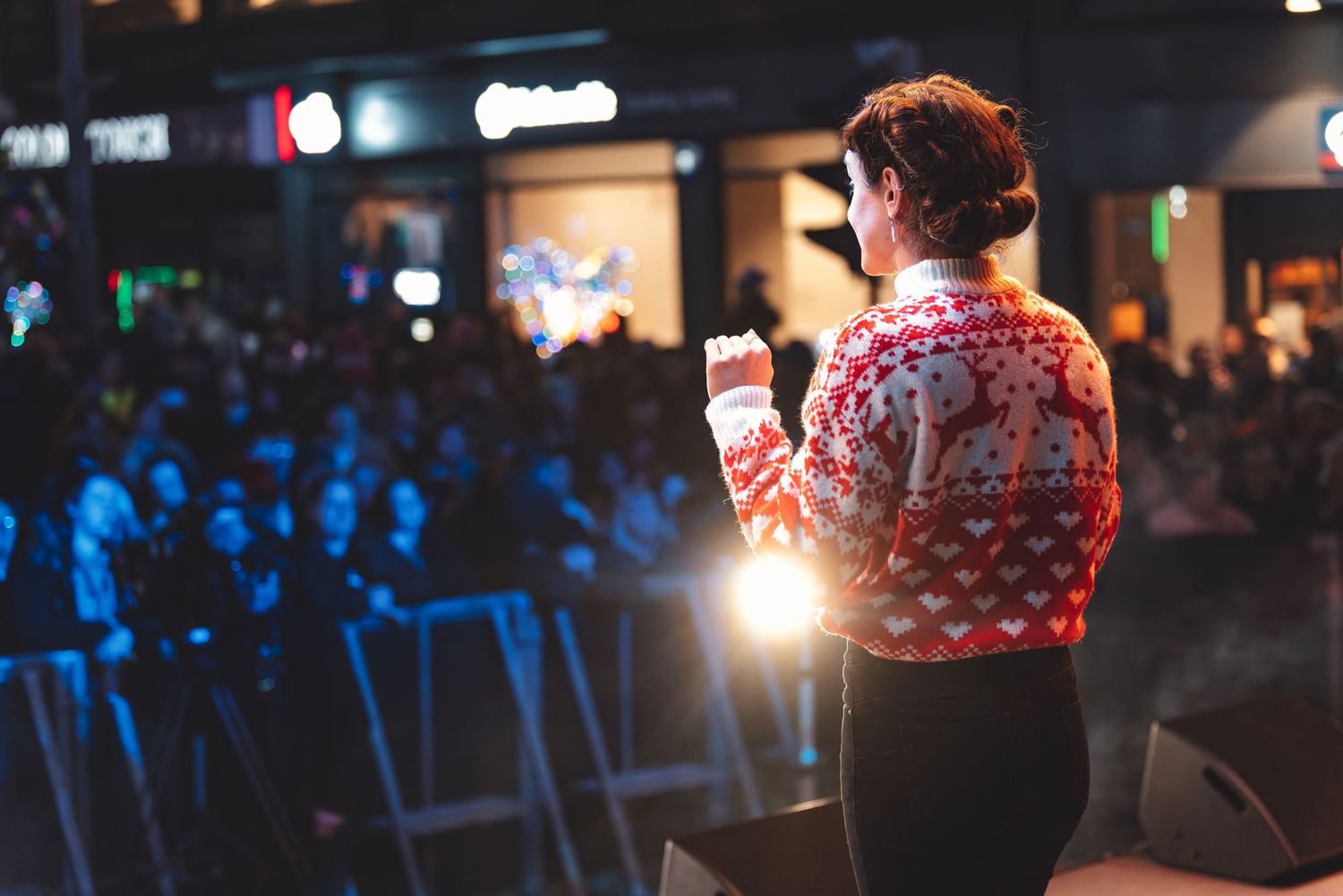 Performer seen from behind facing a blue-lit crowd at a venue night event, atmospheric live event photography Southampton