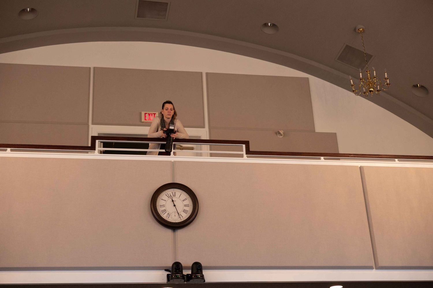 A wall clock mounted beneath an arched ceiling in an event space.