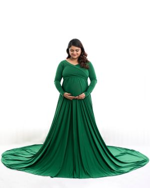 Maternity portrait in emerald green gown with dramatic floor-length train.