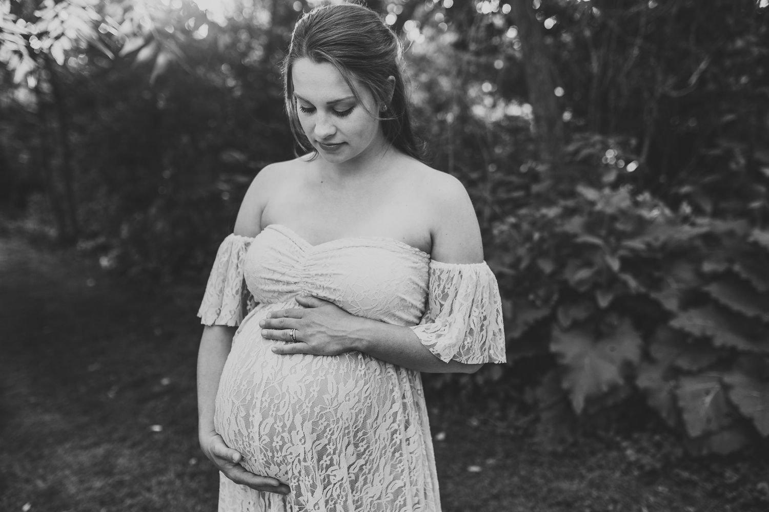 Portrait of a woman gazing down at her pregnant belly
