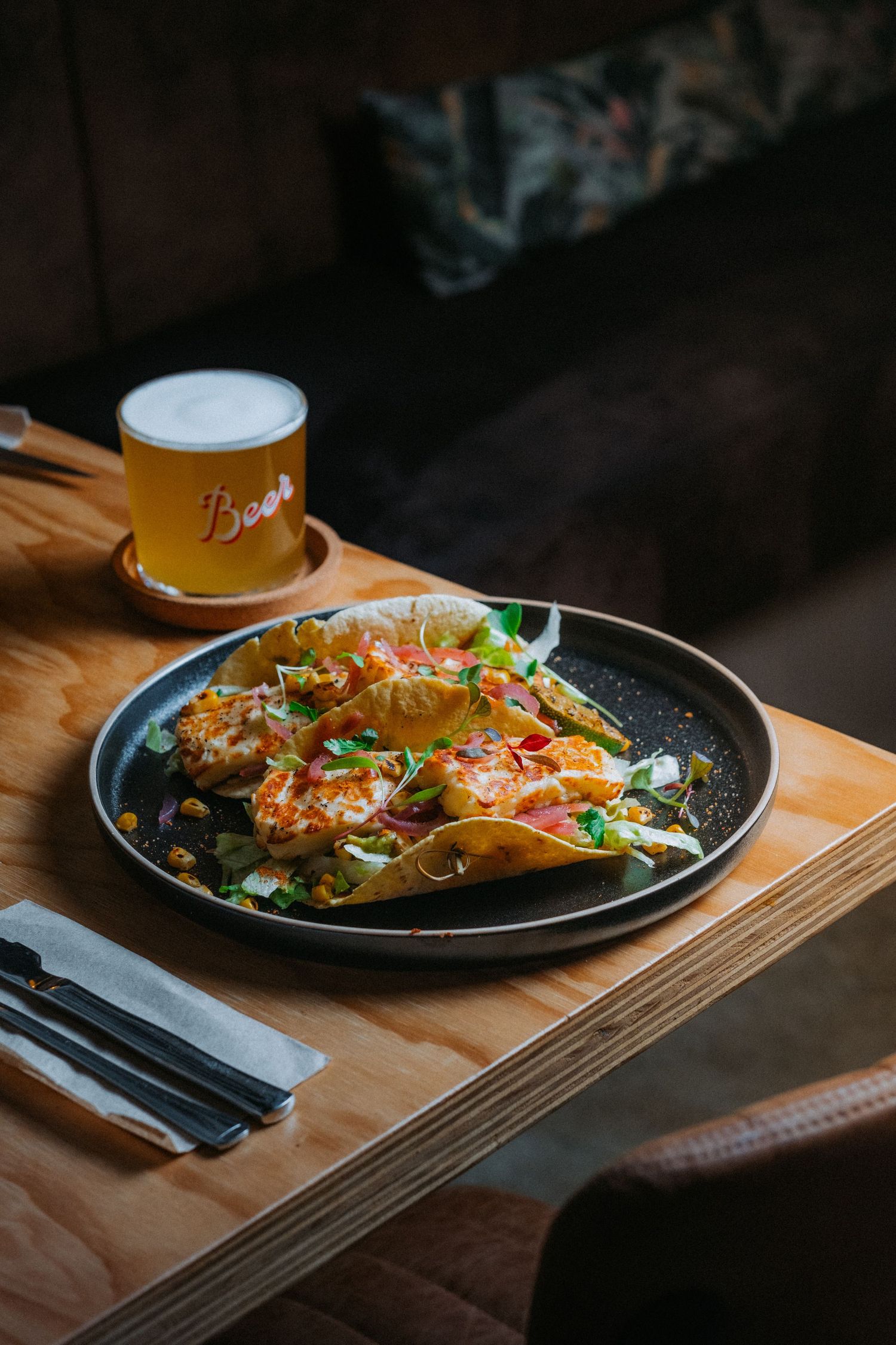 Halluomi tacos on a table with a pint of beer