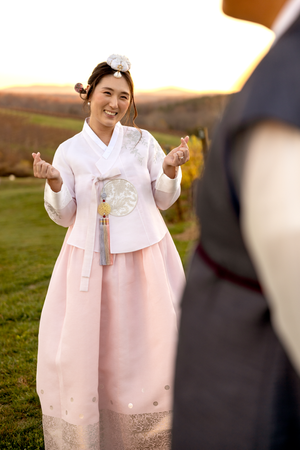 Person in traditional Korean hanbok dress gesturing joyfully at Stone Tower Winery
