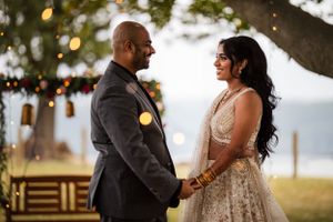A couple shares an intimate moment during their outdoor wedding celebration at golden hour.