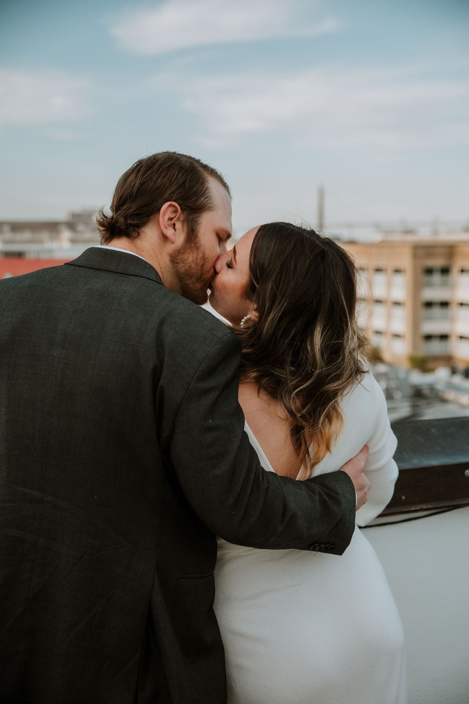 A couple shares a kiss with a view of the Ravenel Bridge in the background