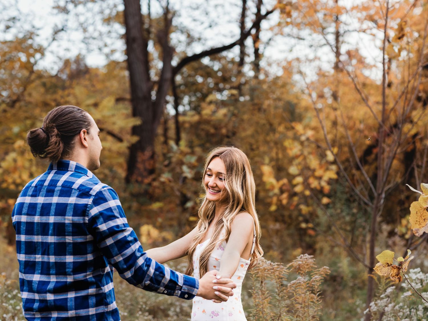 fall couples photography session of young couple looking at each other in field