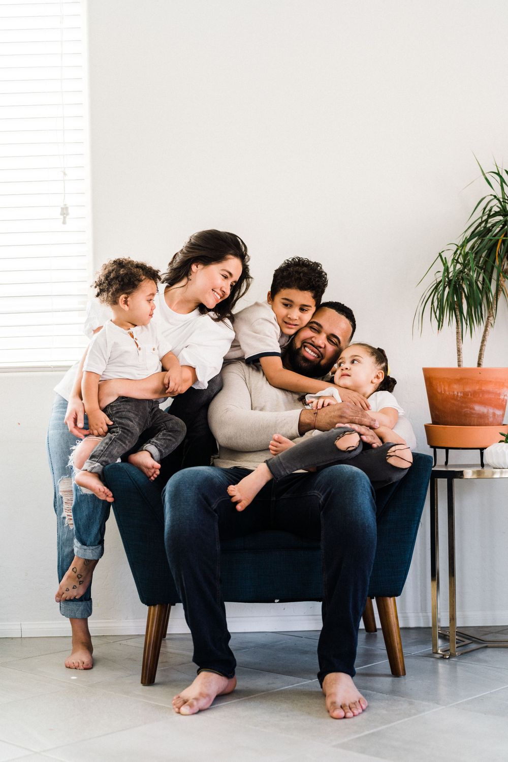 A family shares joyful moments together on a comfortable armchair in their living room.