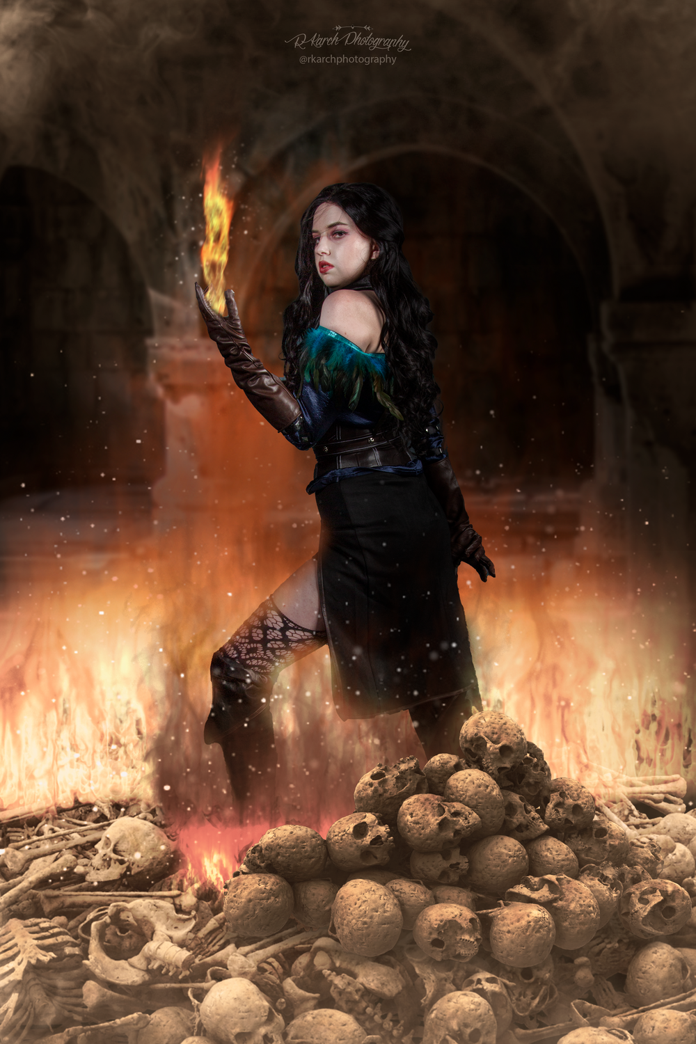 Gothic fantasy scene showing a figure conjuring fire in a stone chamber filled with skulls.