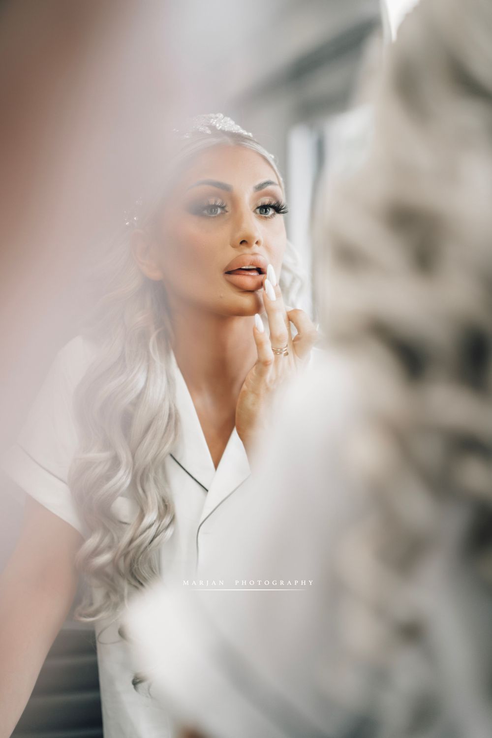 Soft focus portrait of bride getting ready with platinum blonde hair and natural makeup.
