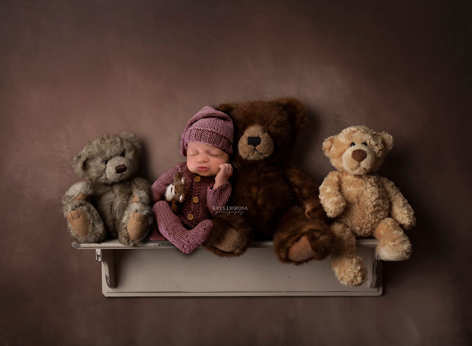 Artistic newborn portrait with teddy bears on wooden shelf against brown backdrop.