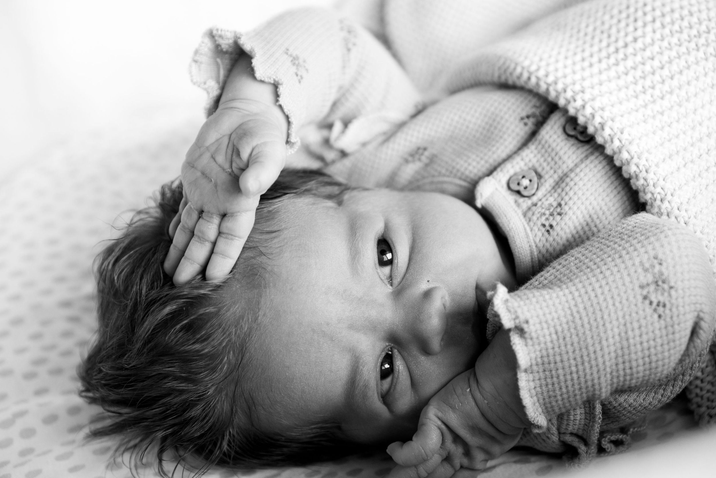 Close up photograph of newborn baby stretching