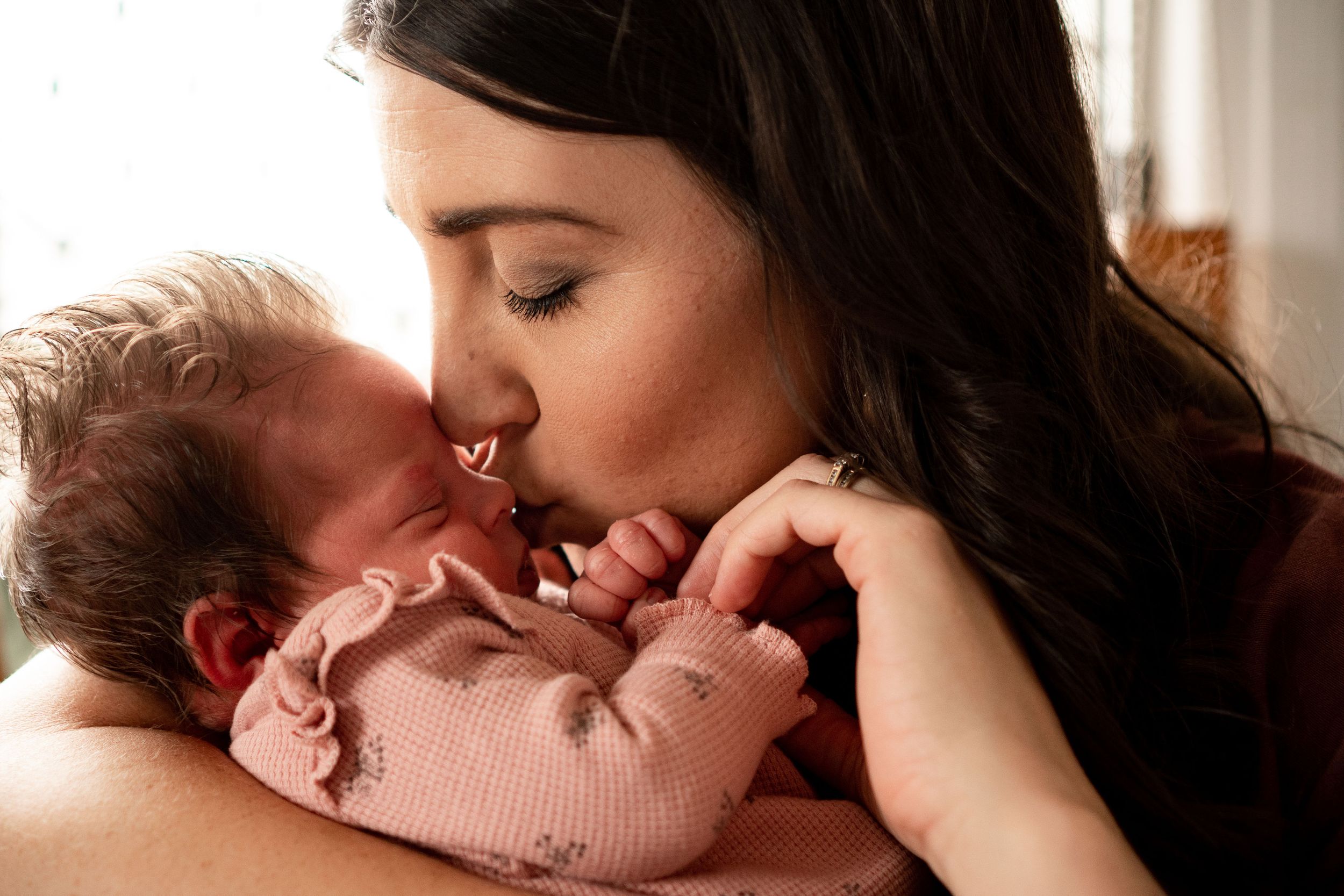 Mother kissing newborn baby