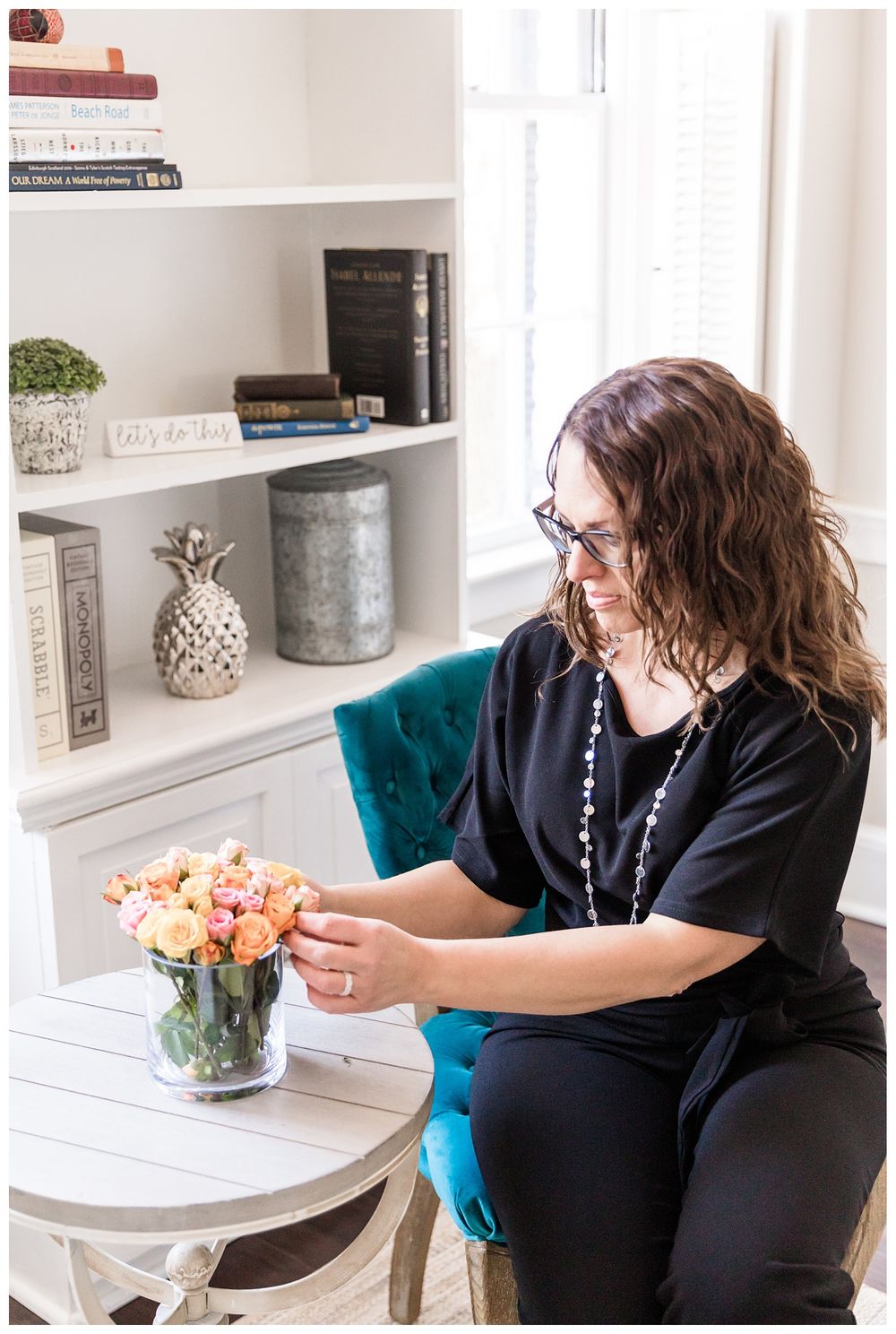 Realtor fixing flower arrangement on table
