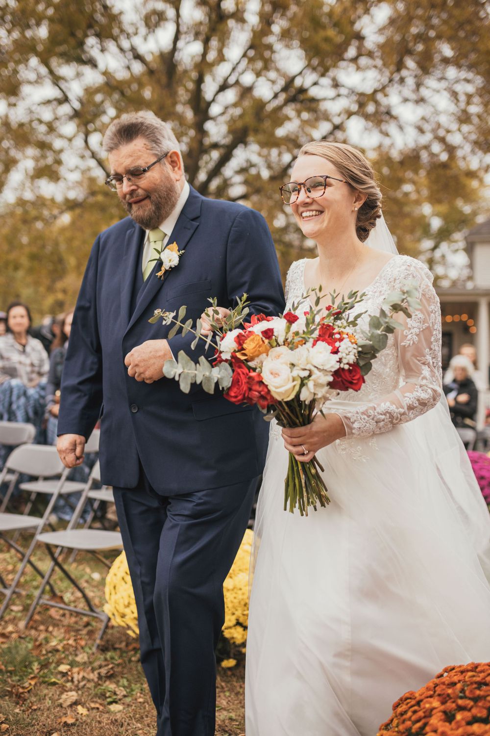 A joyful autumn wedding ceremony with colorful fall flowers and foliage.