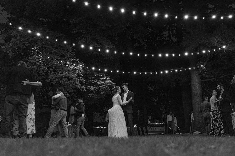 String lights illuminate outdoor evening celebration under dark sky.