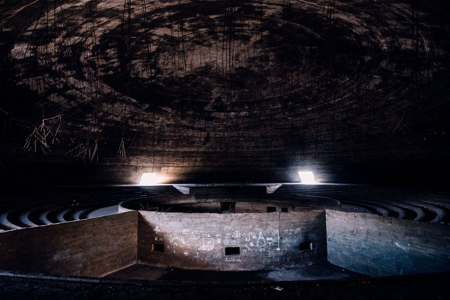 Dark abandoned underground bunker or tunnel with curved walls and mysterious lighting.