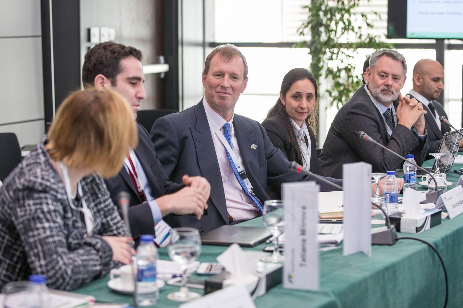 Business professionals seated at conference table during corporate meeting.