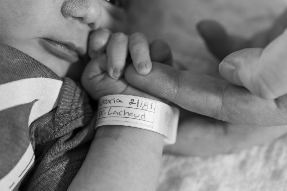Close-up black and white shot of a newborn's hospital identification bracelet.