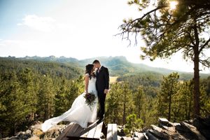 A scenic mountain wedding photo session with sunlight streaming through the trees in the beautiful Black Hills.