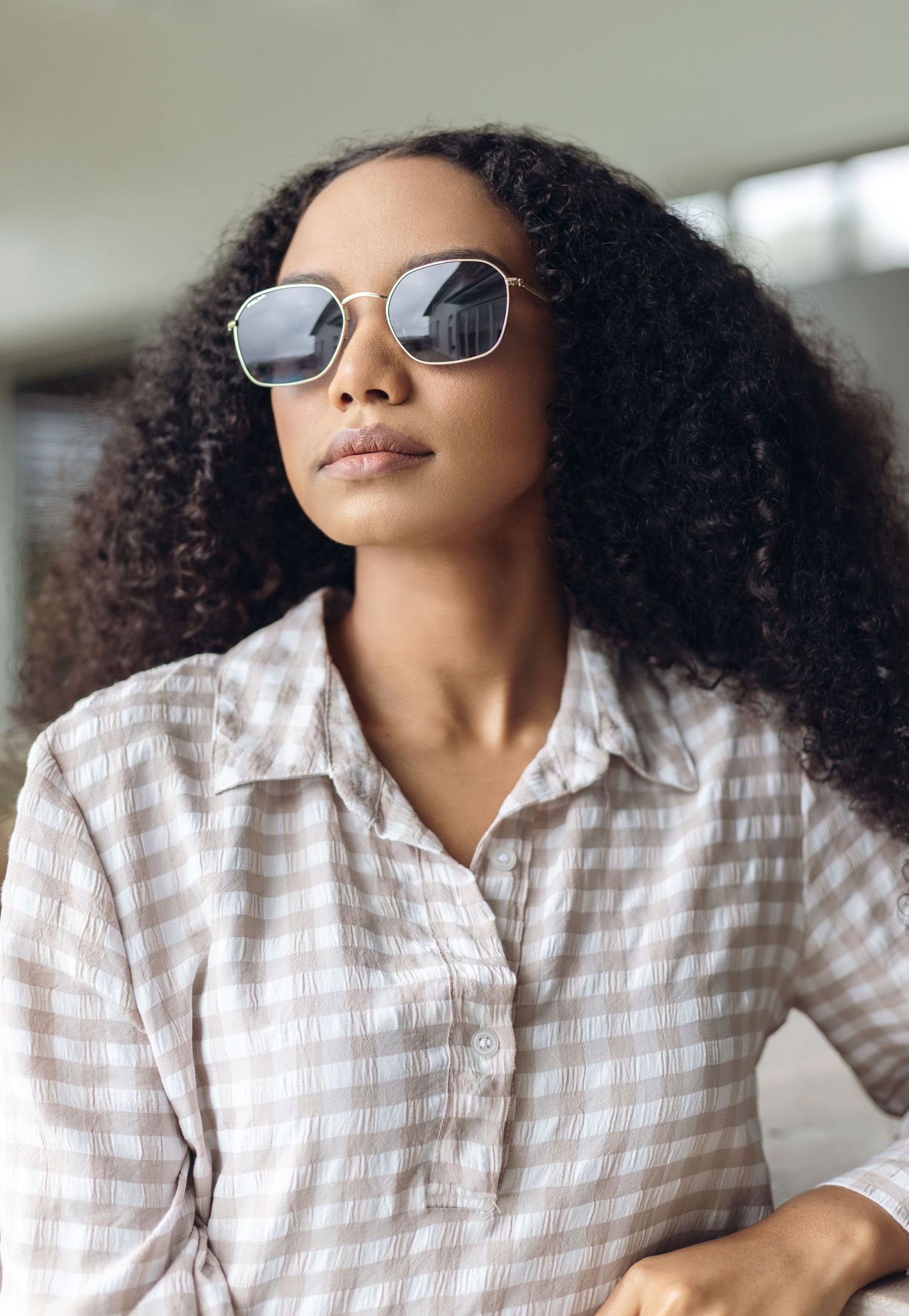 Stylish sunglasses worn with a striped shirt in natural lighting.