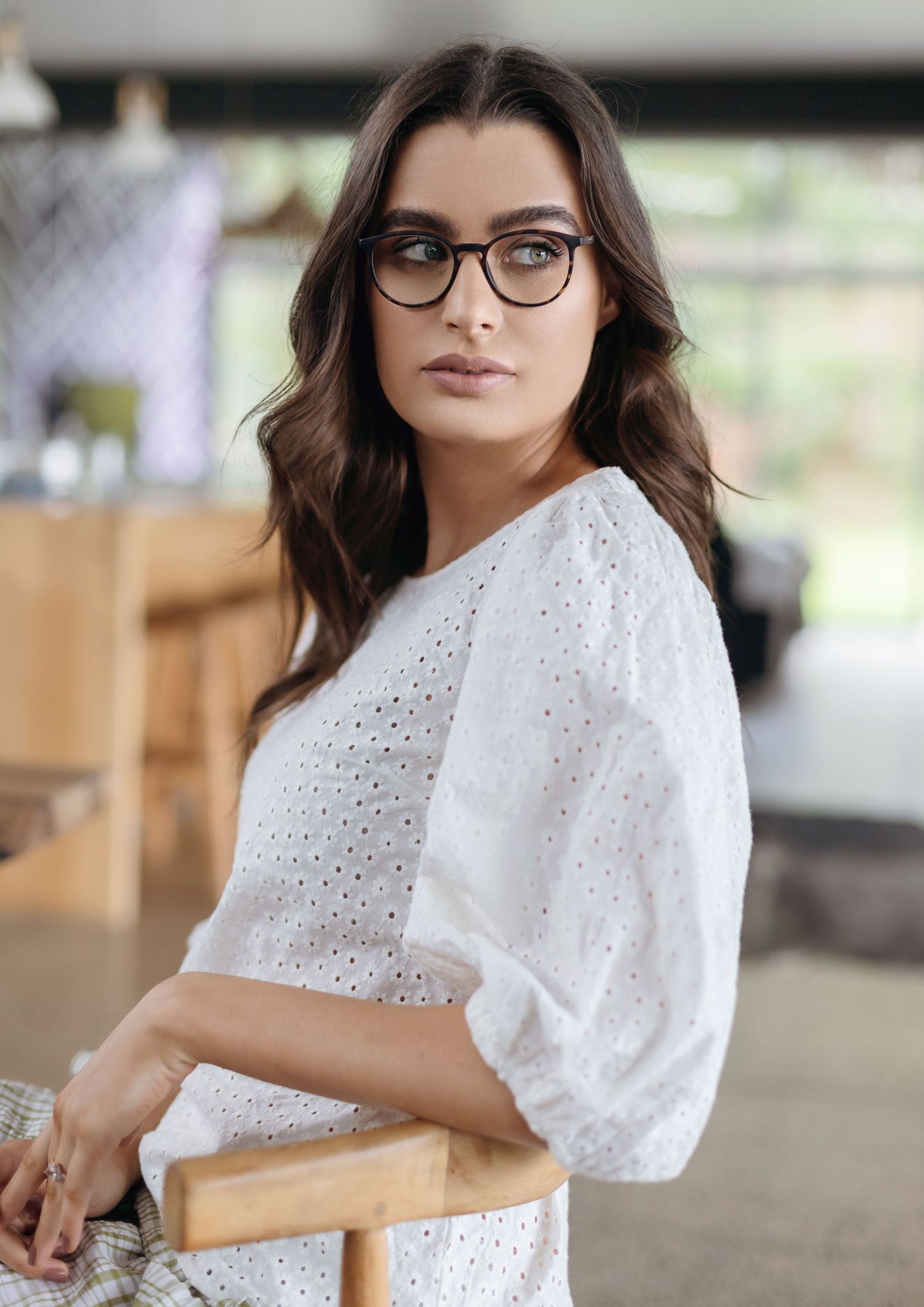 Elegant eyewear paired with white eyelet lace top in casual setting.
