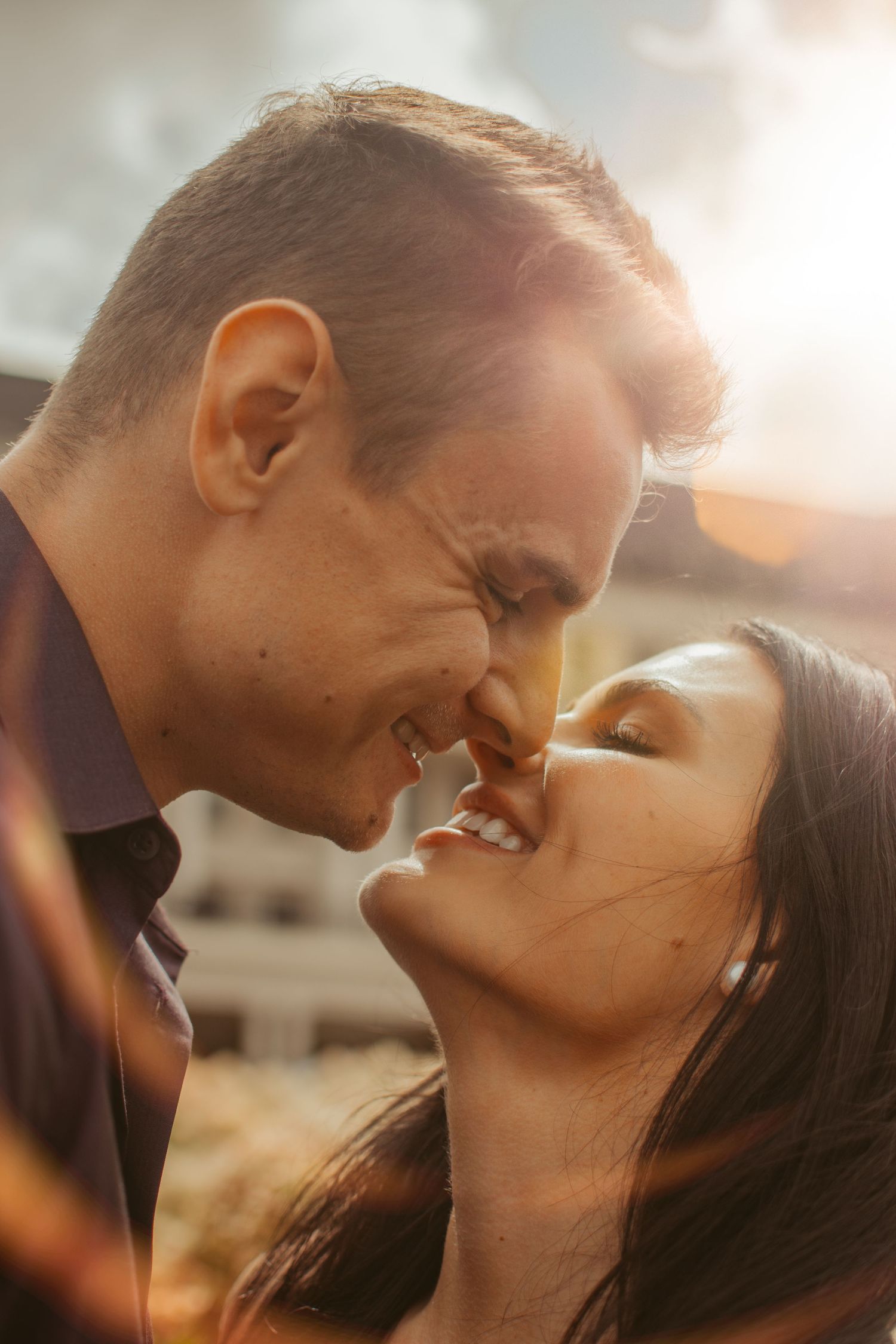Intimate close-up of a romantic couple sharing a tender moment at sunset.