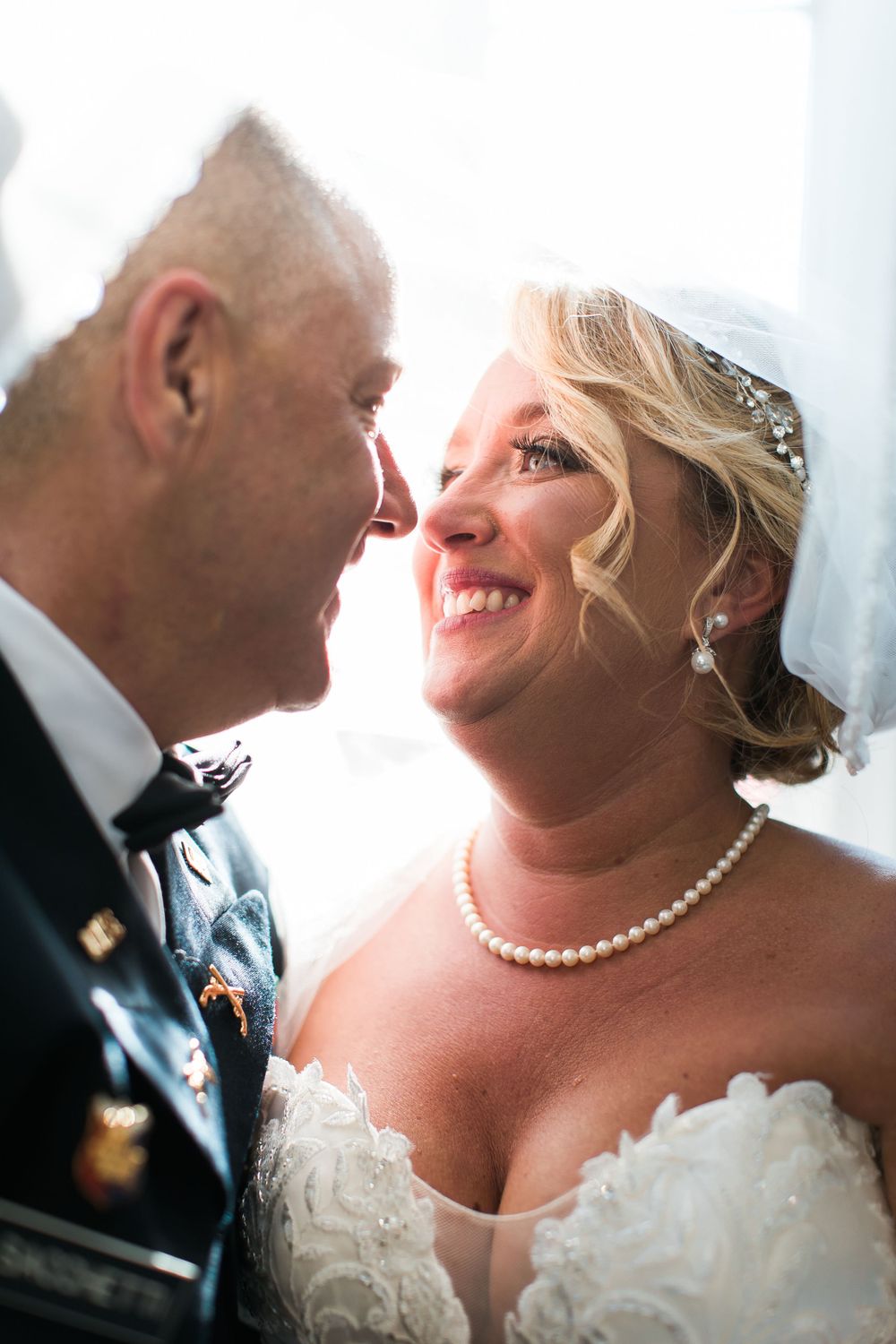 Close-up of wedding couple sharing an intimate moment in natural light.