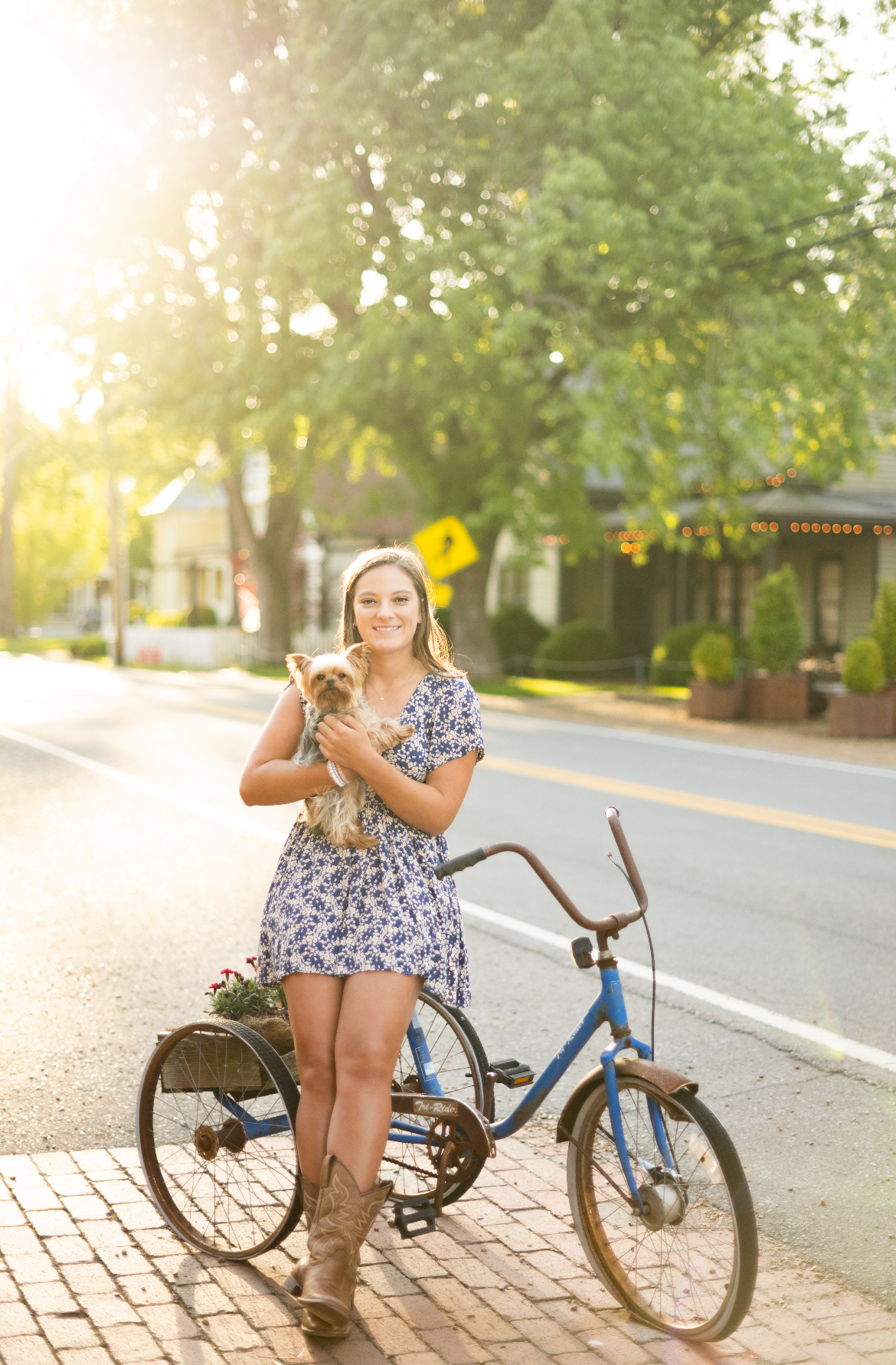 Summer portrait session with vintage blue bicycle on a sunlit street.