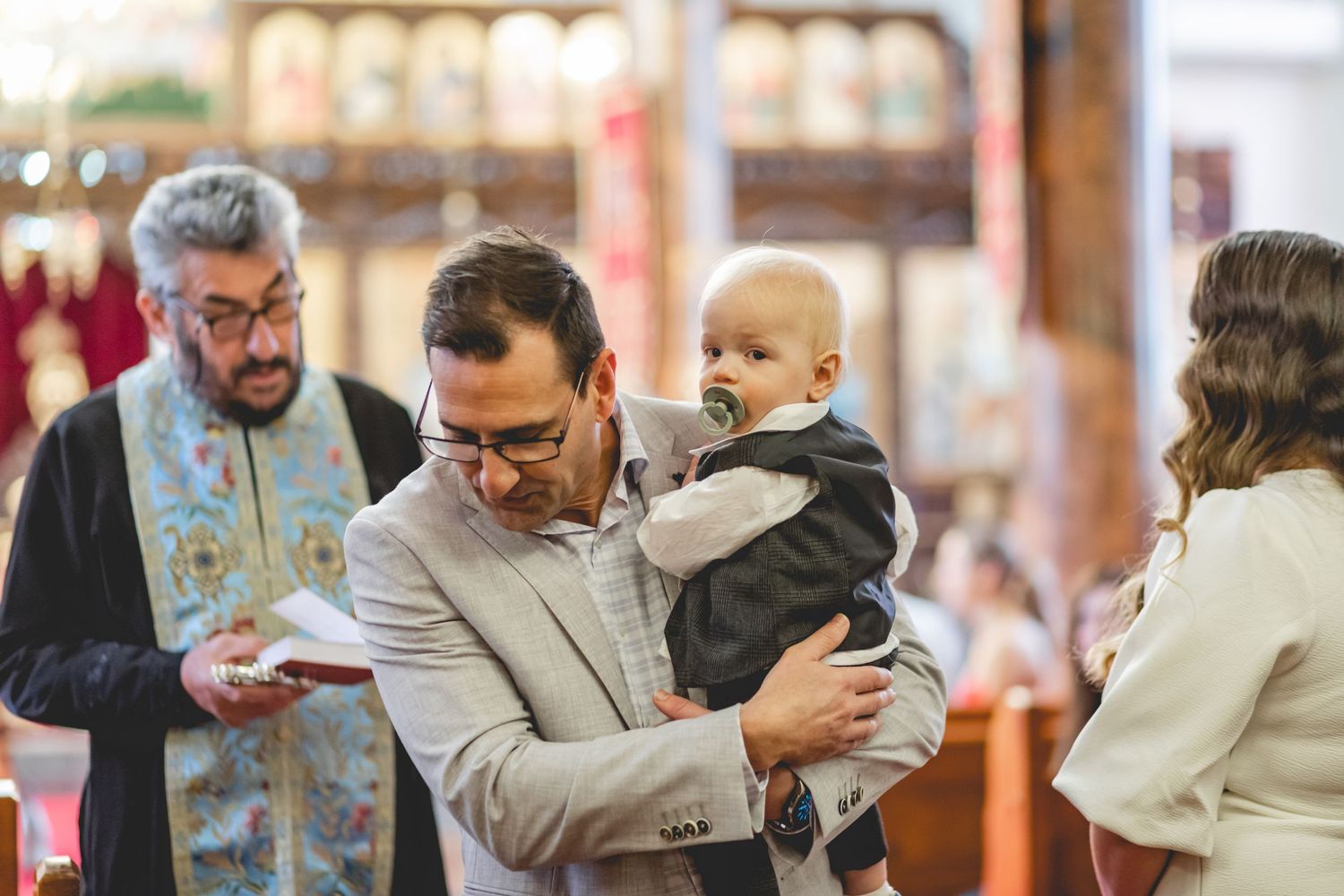 Intimate religious ceremony taking place in traditional church interior with ornate decoration.